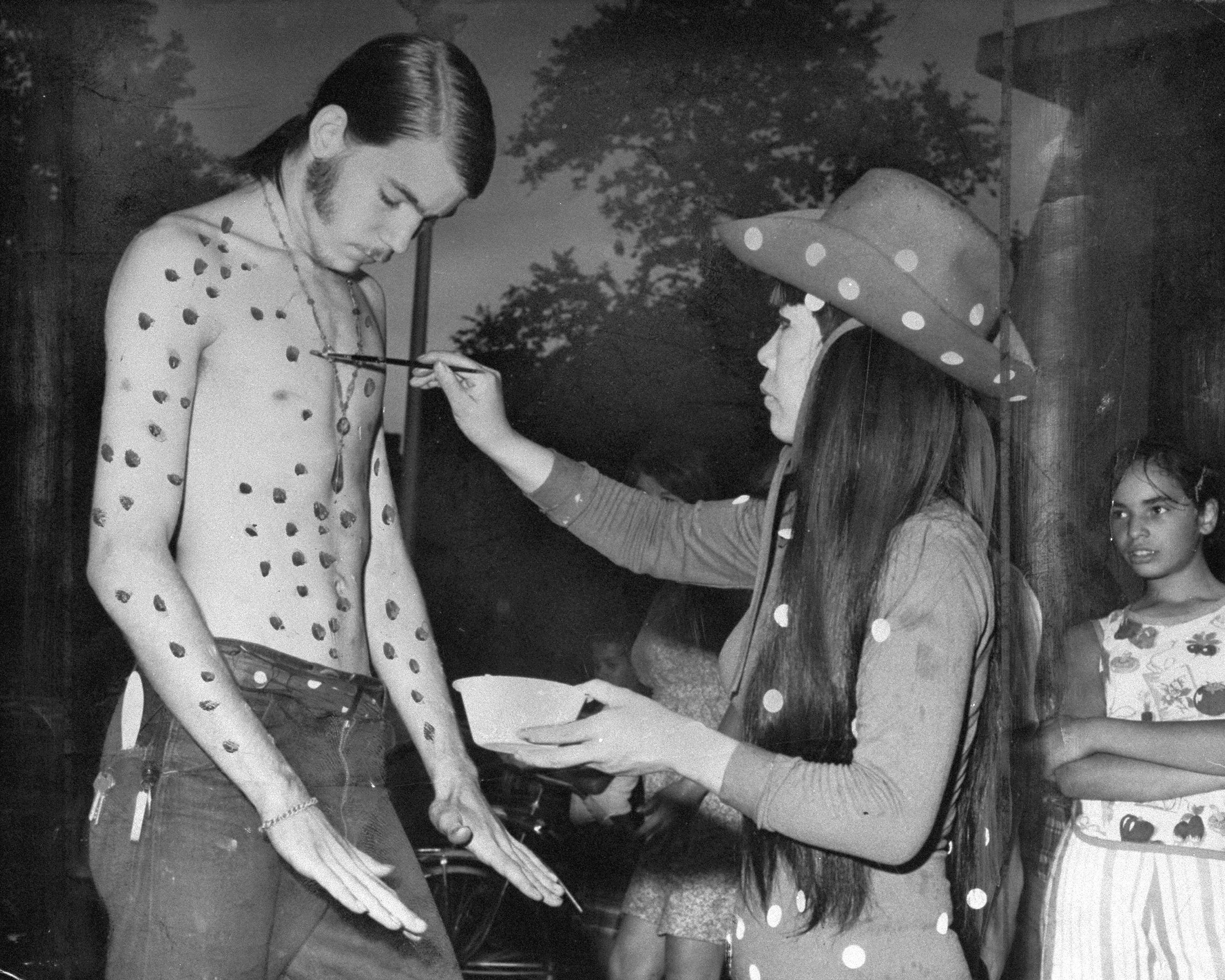 Kusama crta tufne muškarcu po golom telu