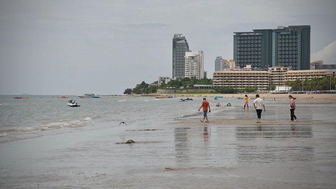 ljudi šetaju plažom u pataji