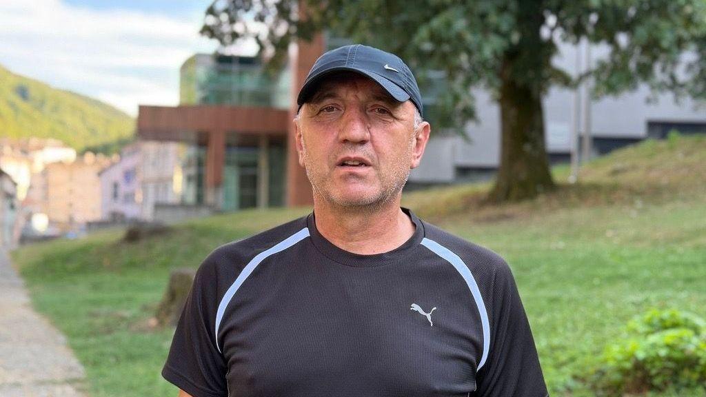 Dragan Cvetinović gleda u kameru, u tamnoj je majici kratkih rukava, ima kačket na glavi, iza njega zelena površina i zgrada