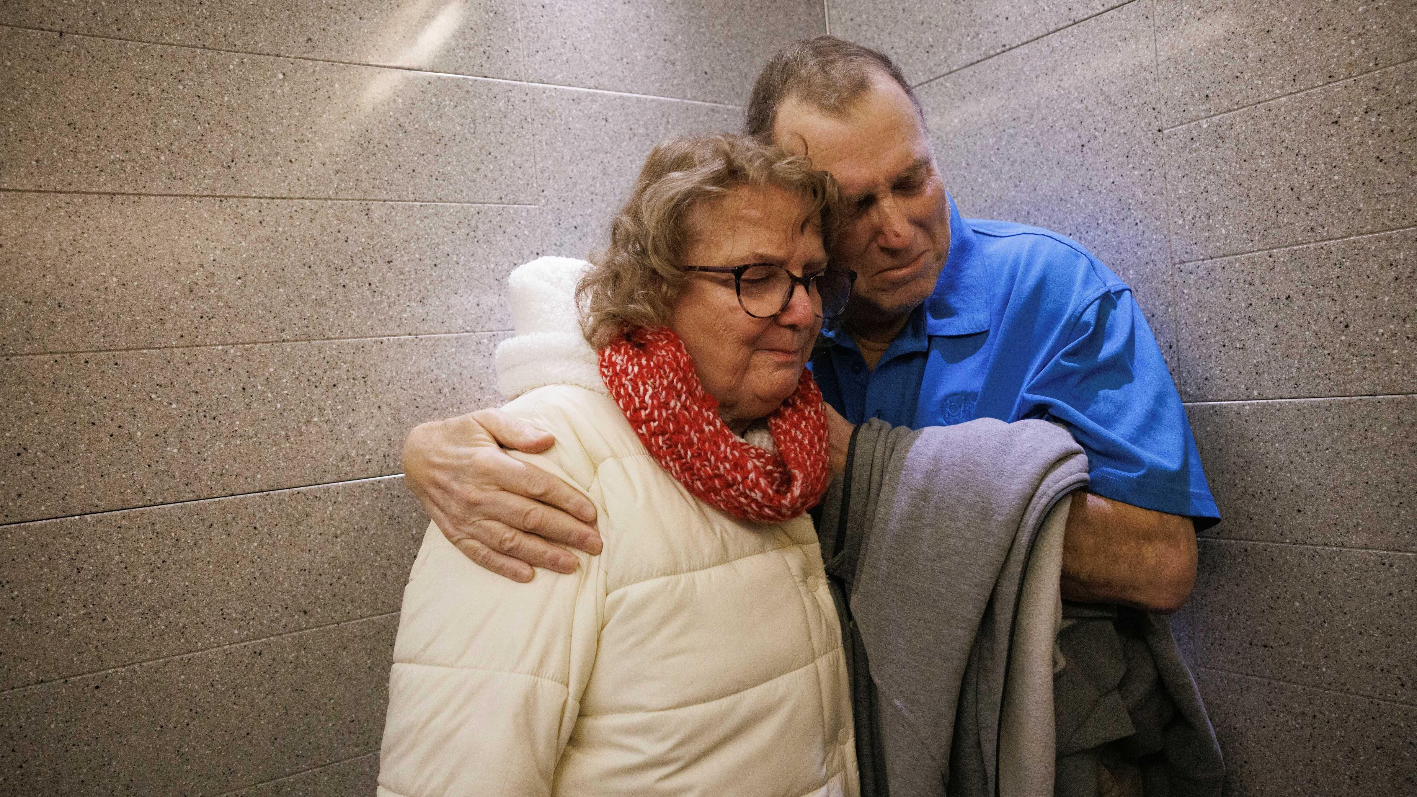 Muškarac u plavoj majici glavom naslonjen na ženu 
