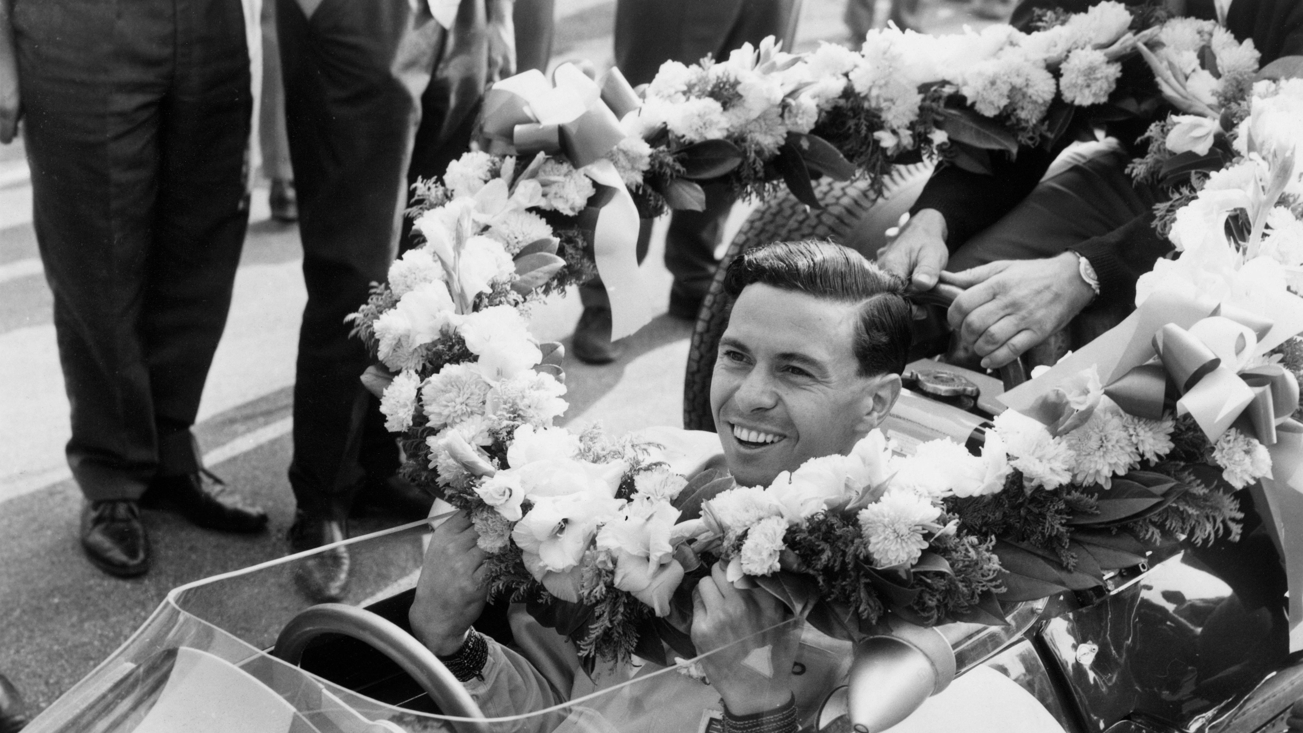 Škot Džim Klark sa vencom od cveća koji mu je uručen pošto je 1963. pobedio na trci u Monci i osvojio prvu od dve svetske titule za Lotus
