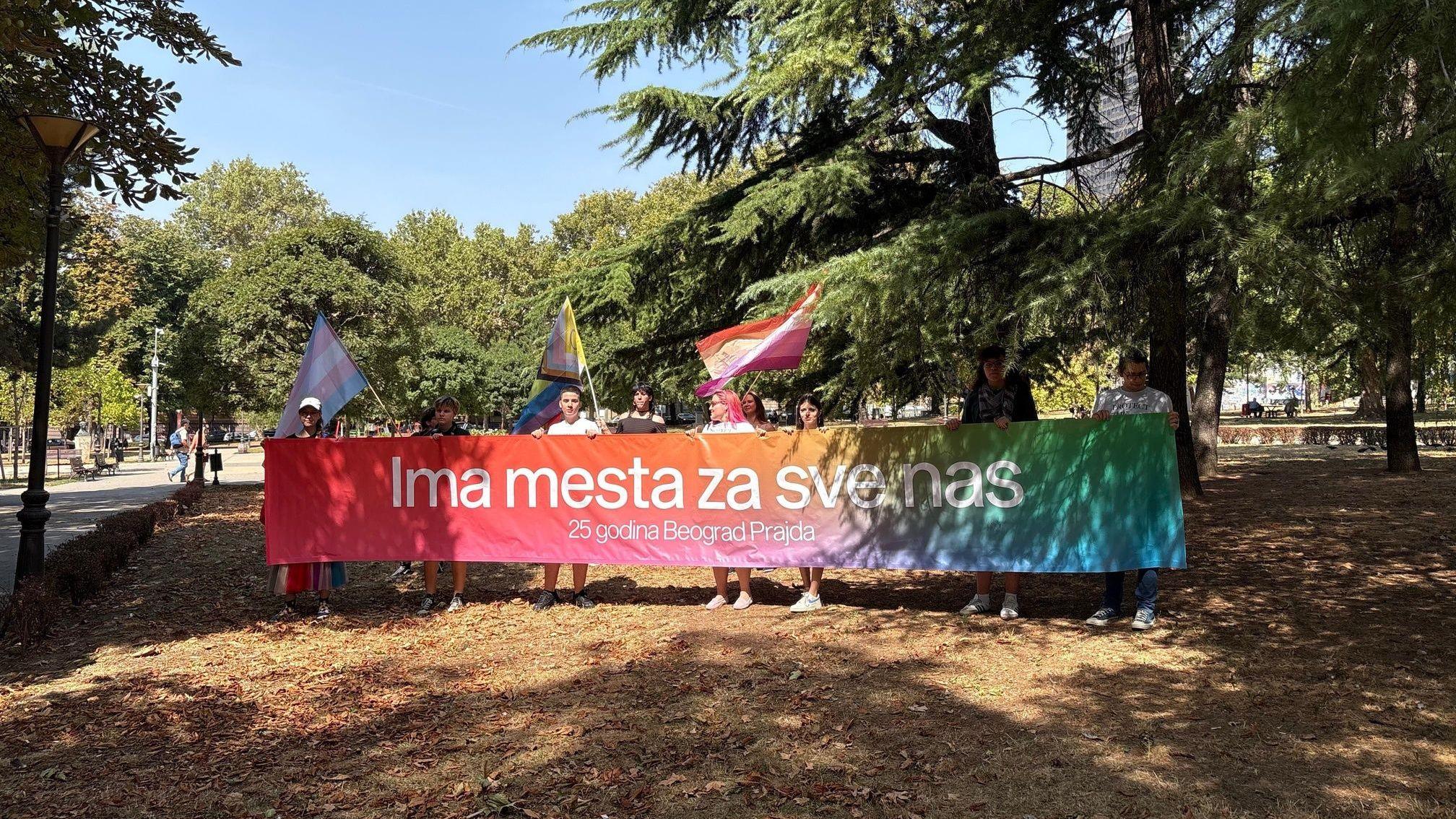 ljudi drže transparent u duginim bojama 