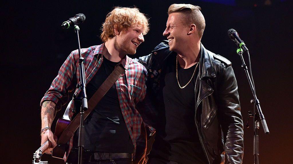 Ed Širan tokom nastupa sa Meklmorom na muzičkom festivalu iHeartRadio 2014. godine, zagrljeni gledaju jedan u drugog, Širan ima kariranu crveno-plavu košulju, a Meklmor je u kožnoj jakni 