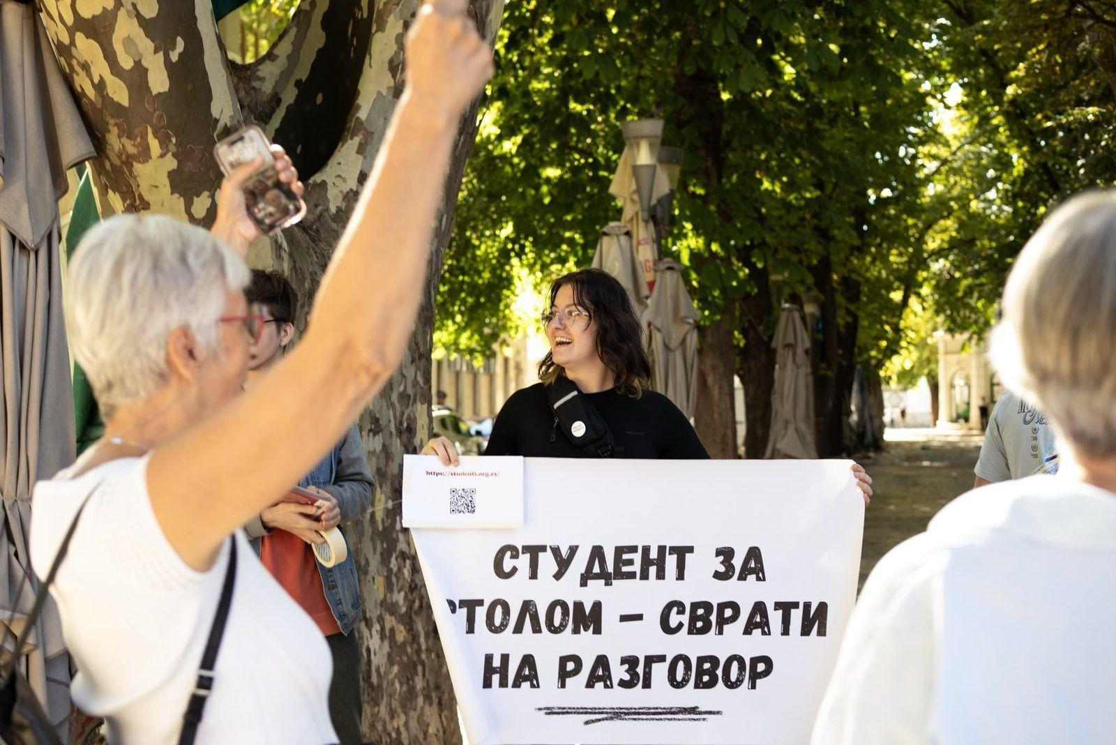 Žena podigla ruke ispred transparenta