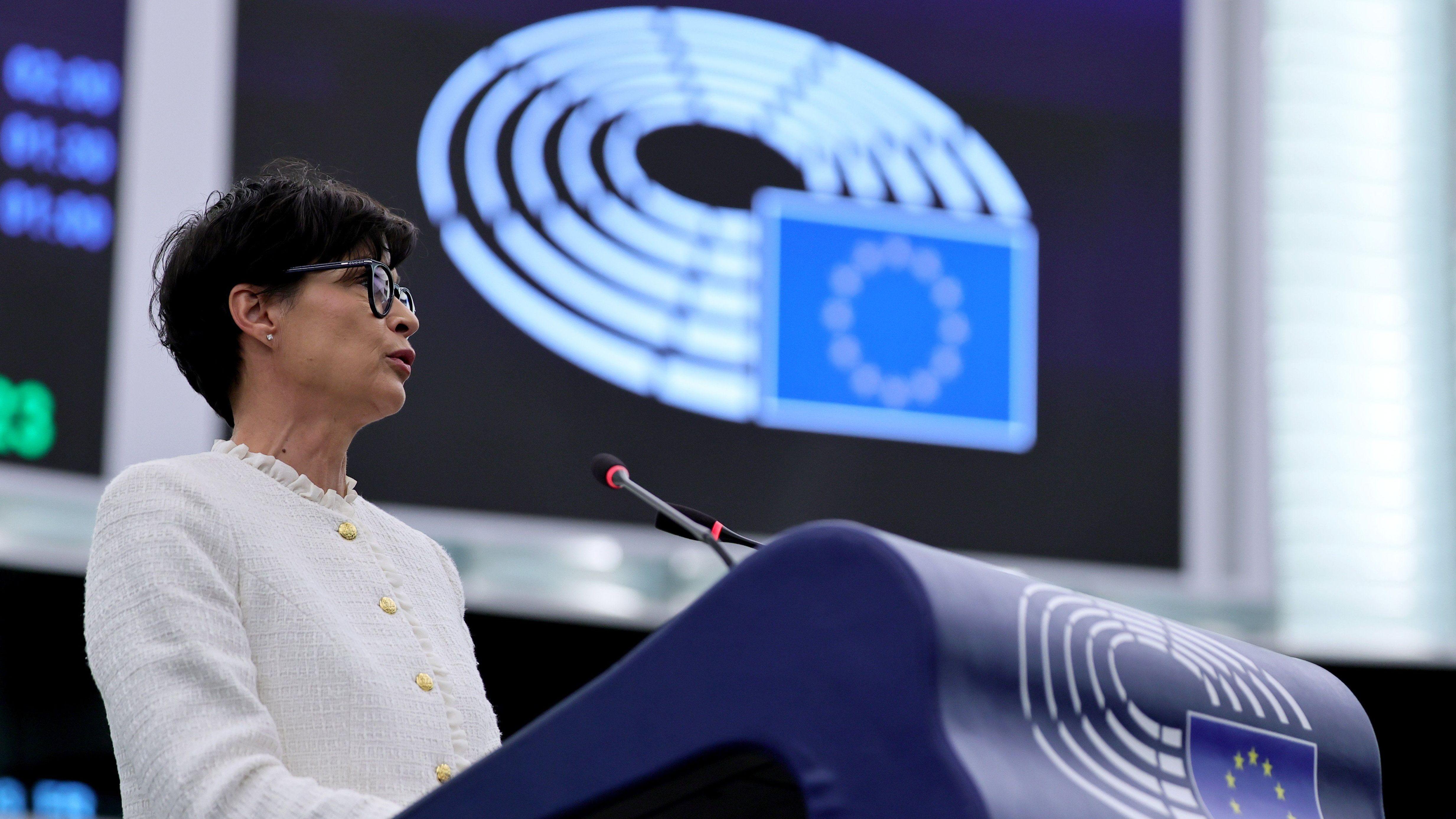 Marta Kos u belom sakou za govornicom sa znakom EU