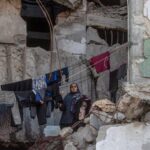 Palestinka skuplja veš koji visi unutar uništene zgrade u gradu Gazi