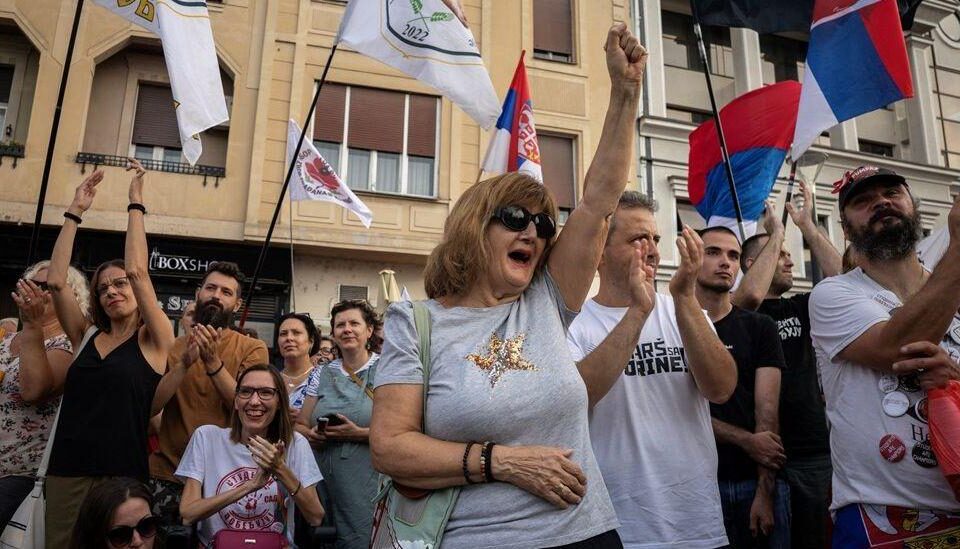 Žena sa podignutom pesnicom u masi na mitingu