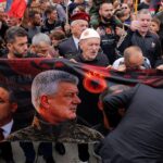 Nekoliko muškaraca drži veliki transparent sa slikom Hašima Tačija u vojničkoj uniformi