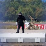 Policijski istražitelj radi na pisti sa robotom sposobnim za deaktiviranje eksploziva u blizini ukrajinskog teretnog aviona Antonov na aerodromu Lajpcig/Hale 5. avgusta