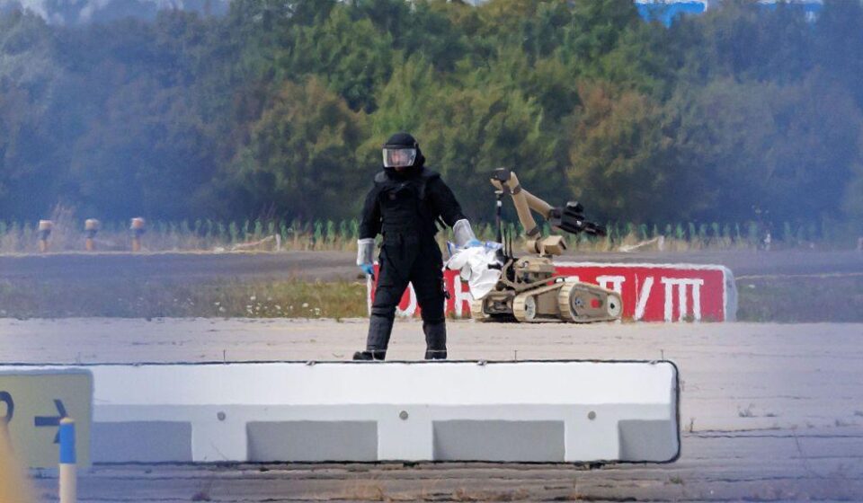 Policijski istražitelj radi na pisti sa robotom sposobnim za deaktiviranje eksploziva u blizini ukrajinskog teretnog aviona Antonov na aerodromu Lajpcig/Hale 5. avgusta