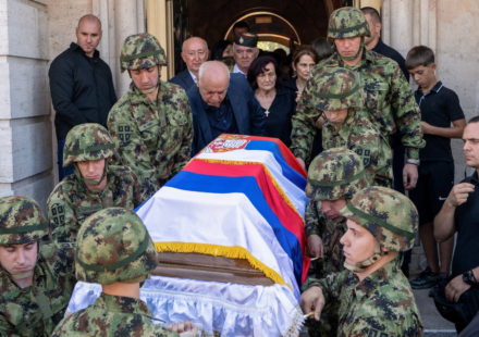 Vojnici nosi kovčeg prekriven zastavama Srbije i Republike Srpske, iza ide žena u crnini, okolo su ljudi