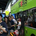 Nekoliko putnika u Singapuru izlazi iz zelenog autobusa