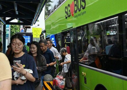 Nekoliko putnika u Singapuru izlazi iz zelenog autobusa