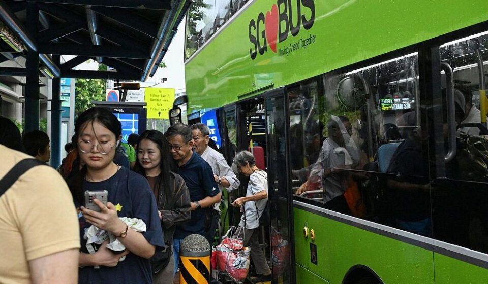 Nekoliko putnika u Singapuru izlazi iz zelenog autobusa