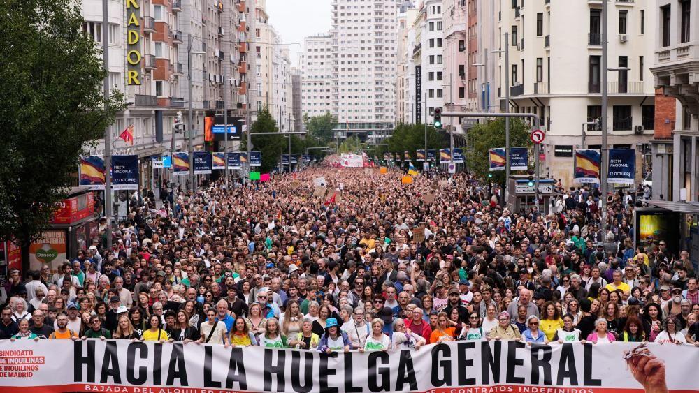 Velika gomila ljudi zauzima celu široku ulicu u Madridu. Ljudi ispred drže veliki transparent na kojem piše „hacia la huelga general“ (naslovna strana ulice).
