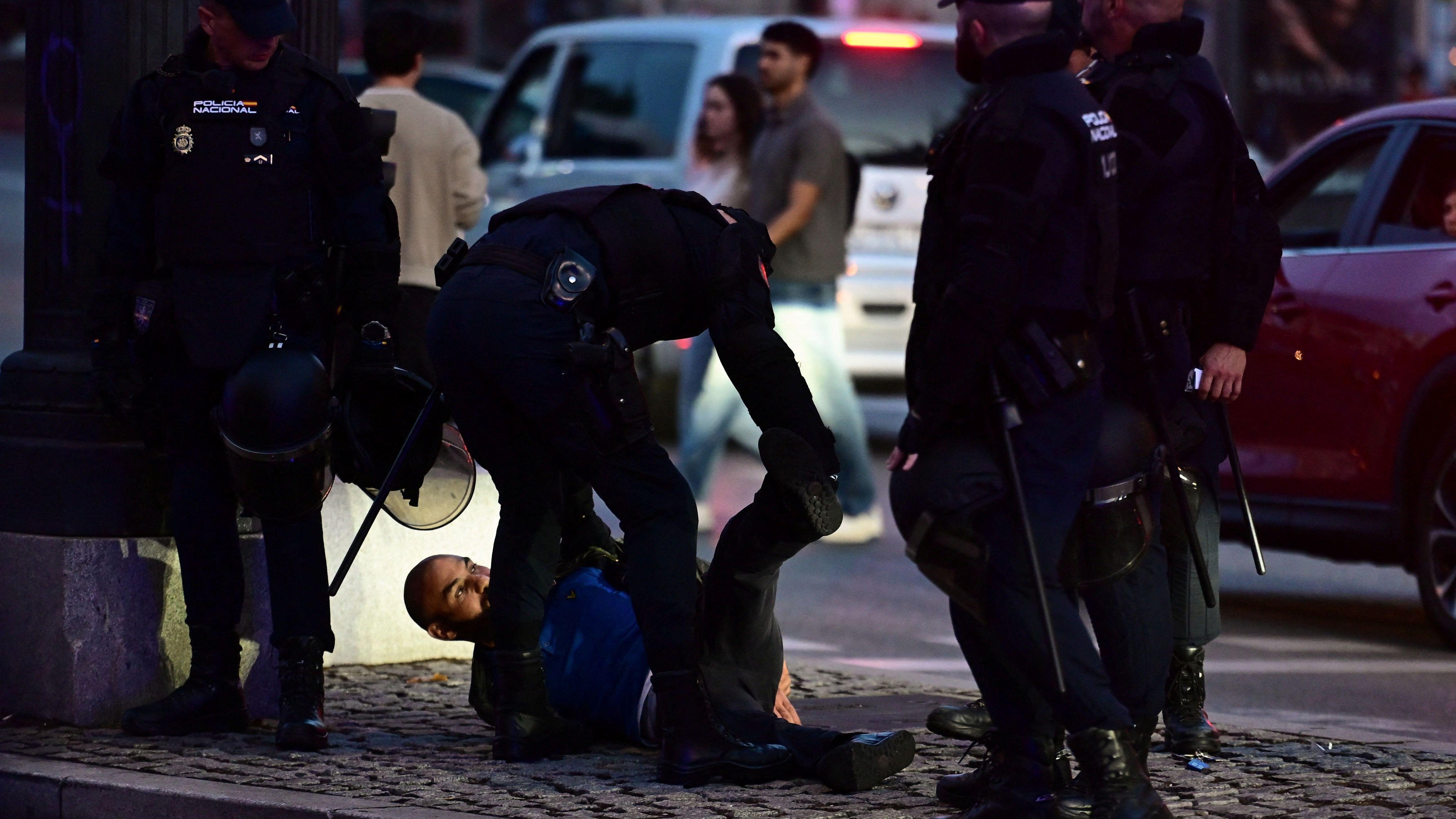 Policija hapsi muškarca koji leži na zemlji