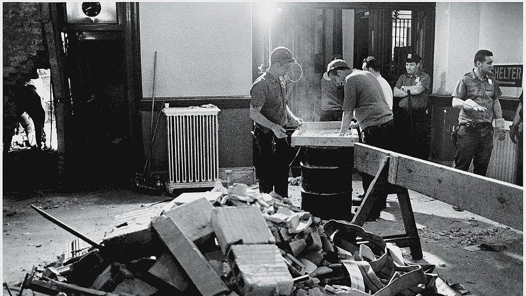 Građevinski radnici i policajci stoje oko ruševina u policijskoj zgradi posle napada bombom Veder andergraunda 1970. godine. Niko nije stradao u napadu