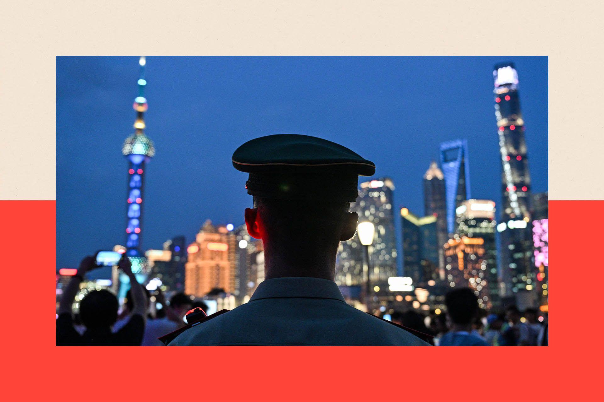 The back of a policeman's head at night against a brightly lit city scape