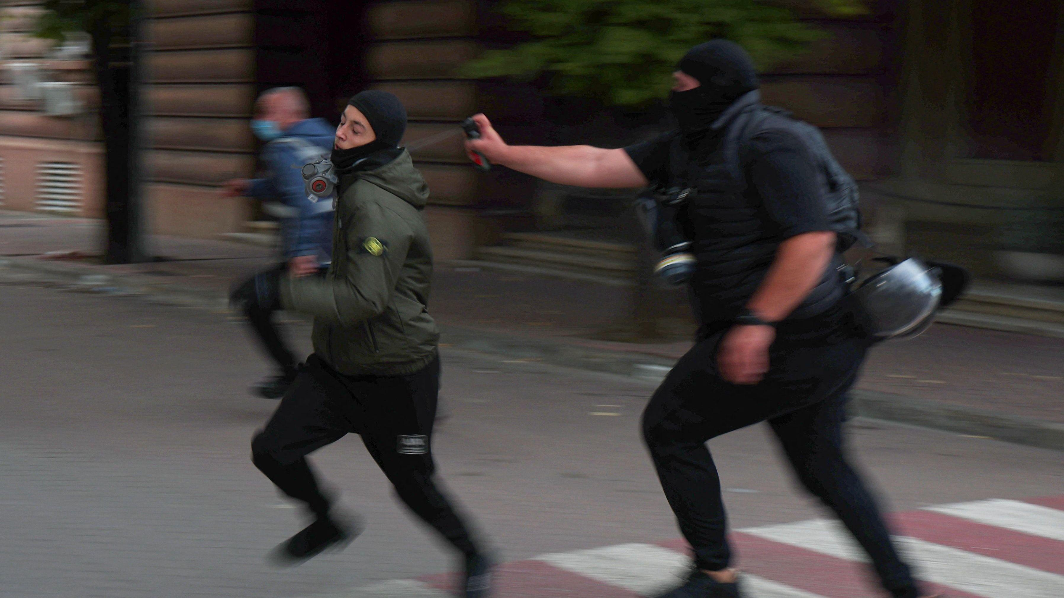Policajac prska demonstranta biber sprejom