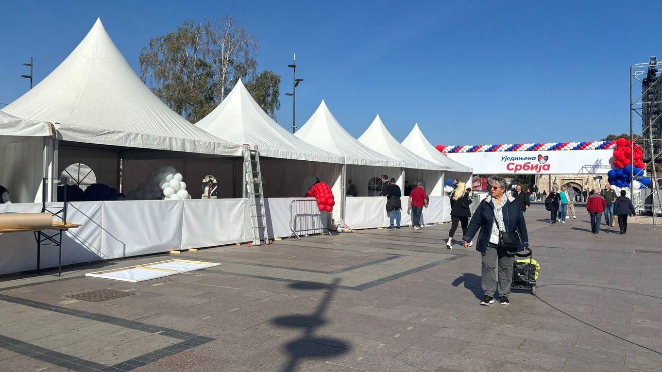 Beli šatori u nizu u daljini postavljena kapija sa nazivom Ujedinjena Srbija 