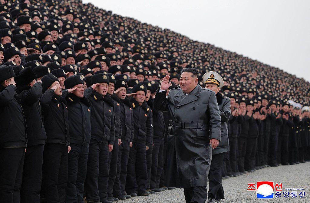 Severnokorejski lider Kim Džong Un u dugom tamnom kaputu prolazi pored redova uniformisanih vojnika koji mu salutiraju 