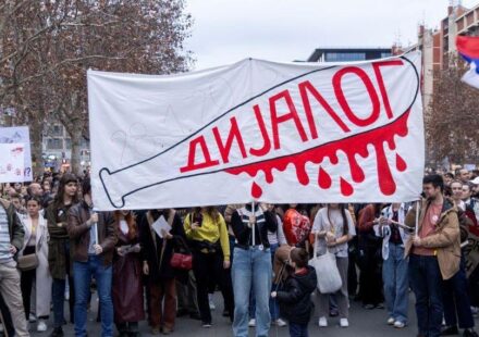 studentski protest sa transparentom na kome je nacrtana bela palica umrljana crvenom krvlju