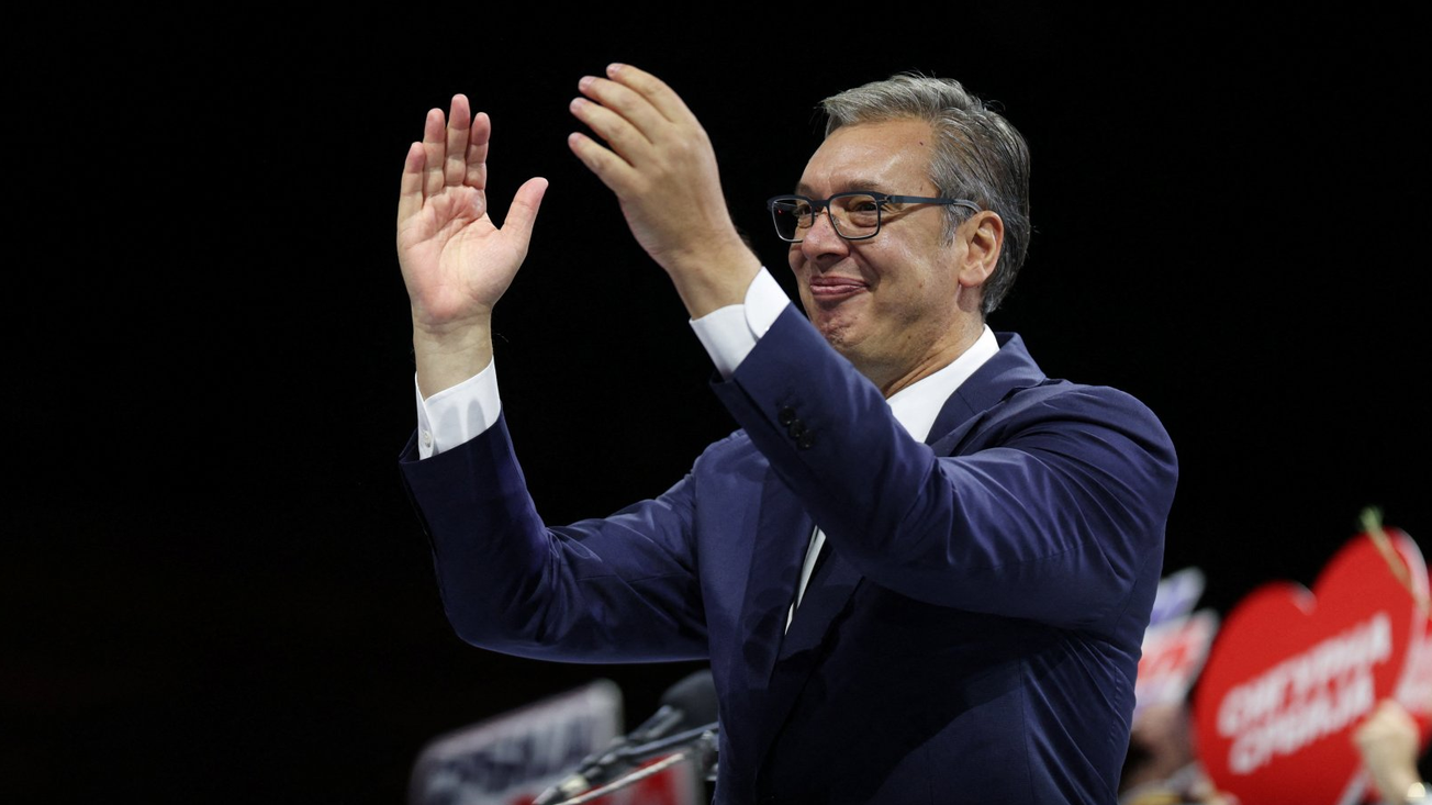 Vučić u odelu uzdignutih ruku, u beloj košulji, smeje se