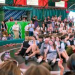 Žene sede u krugu, oko njih ljudi u Minhenu na Oktoberfestu